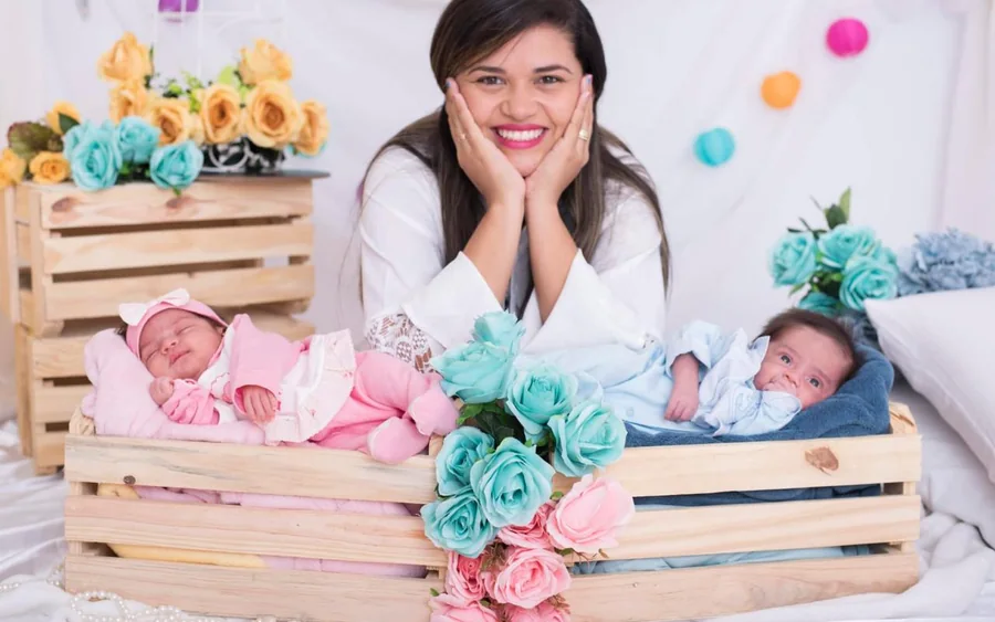 Elaine Almeida sonriendo junto a sus mellizos recién nacidos.